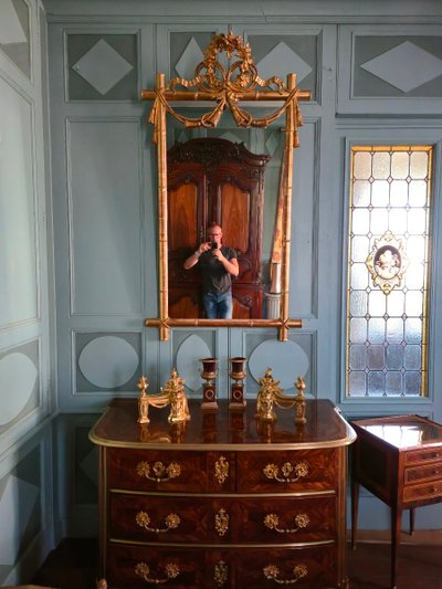 Miroir d'époque Napoléon III à l'imitation du bambou et à décor de draperies à houppes.
