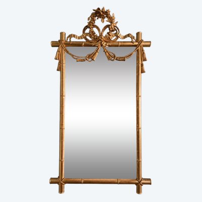 Miroir d'époque Napoléon III à l'imitation du bambou et à décor de draperies à houppes.