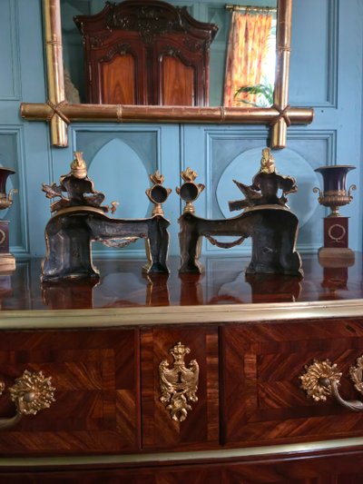 Paire de têtes de chenets aux trophées d'armes en bronze doré, transition Louis XV-Louis XVI