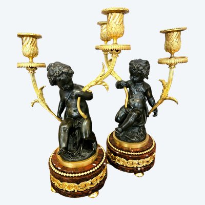 Ein Paar Kerzenleuchter aus vergoldeter und patinierter Bronze mit Putten