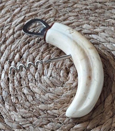 Warthog tusk mounted in a corkscrew shape and bottle opener