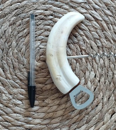 Warthog tusk mounted in a corkscrew shape and bottle opener