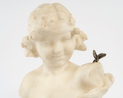 Buste d’une jeune fille au papillon en albâtre, reposant sur un socle en marbre.