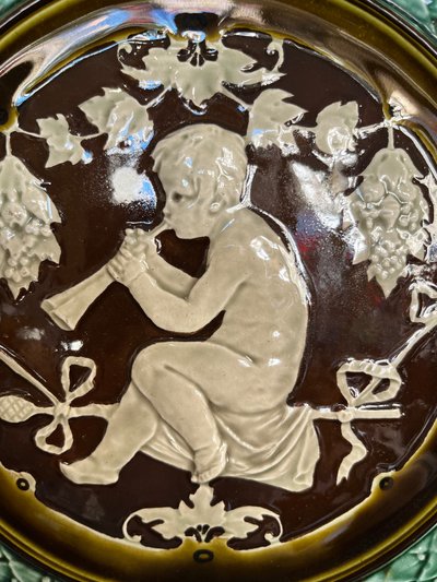 Large earthenware dish decorated with a flute player in the Renaissance style.