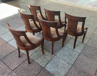 Six varnished mahogany chairs with curved backs.
