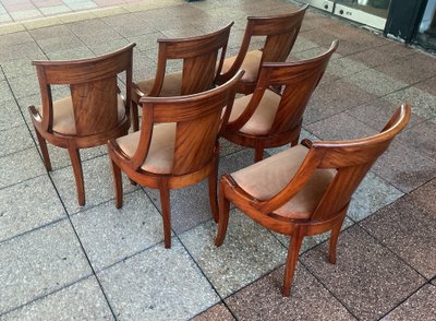 Six varnished mahogany chairs with curved backs.