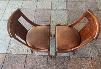 Six varnished mahogany chairs with curved backs.