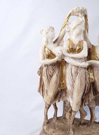 Sculpture titled "The Three Graces," made of white and gold resin, 20th century