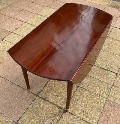 A mahogany dining table with two mahogany extensions