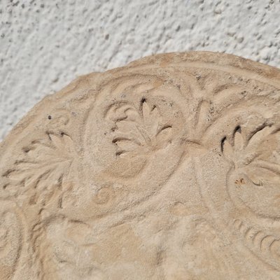 Round stone carved on each face, probably 17th century