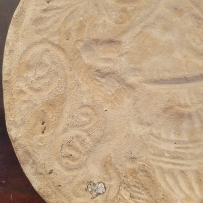 Round stone carved on each face, probably 17th century