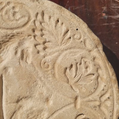 Round stone carved on each face, probably 17th century