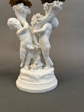 Coppia di candelieri in biscuit di Sévres con putti