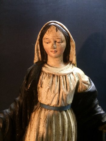 Vergine in legno intagliato su supporto in legno nero.