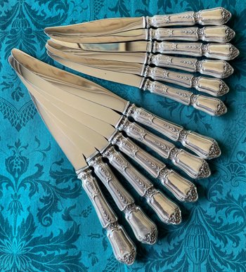 12 knives with silver handles.