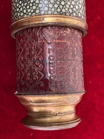 Lorgnette aus grün gefärbtem Rochenleder mit vergoldetem Messingring, an einem mit bordeauxrotem Leder umwickelten Rohr, signiert "Dollond London". XVIII. Jahrhundert