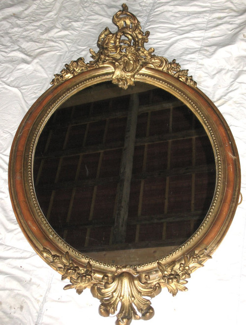 Carved oval mirror in wood and stucco gilded with leaf 19th century