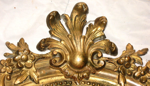 Carved oval mirror in wood and stucco gilded with leaf 19th century