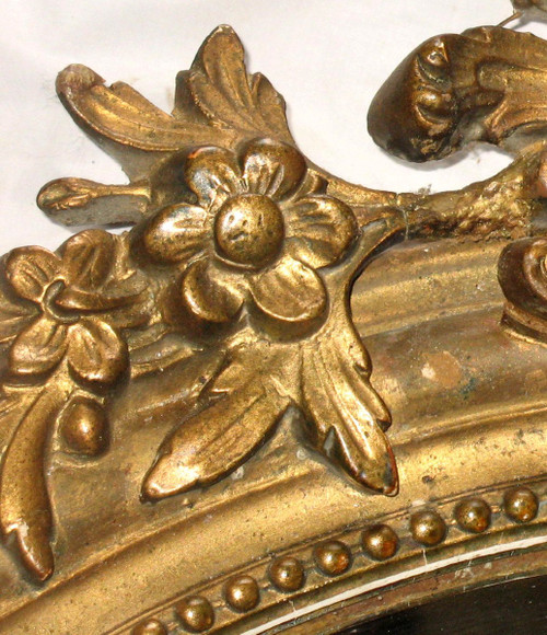Carved oval mirror in wood and stucco gilded with leaf 19th century
