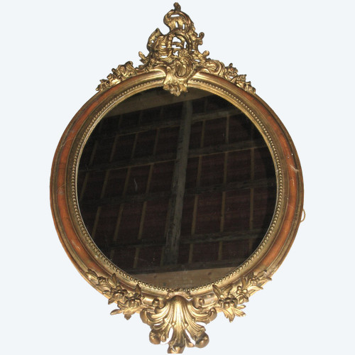 Carved oval mirror in wood and stucco gilded with leaf 19th century