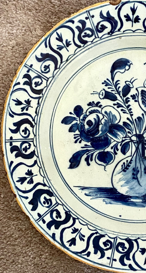 Delft, XVIII Secolo, Piatto Di Terracotta Decorato Con Vaso Bottiglia Fiorito.