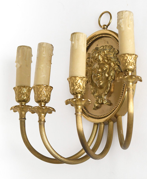 Pair of brass and gilded metal wall lights decorated with a Bacchus mask