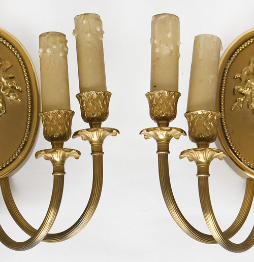 Pair of brass and gilded metal wall lights decorated with a Bacchus mask