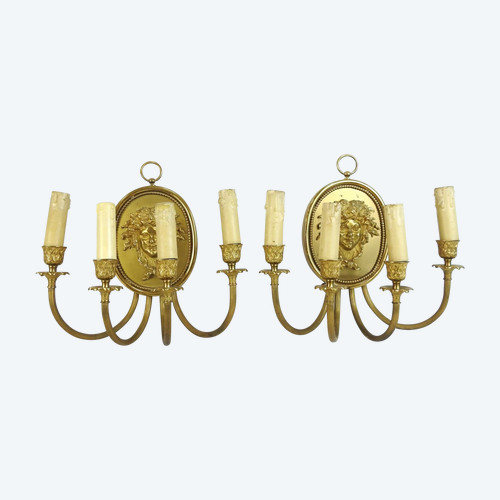 Pair of brass and gilded metal wall lights decorated with a Bacchus mask
