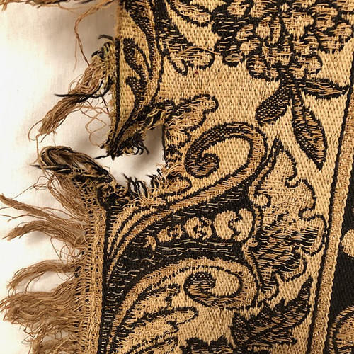 Antique tapestry or table cloth on a black background with rich decorations of Medici vases and flowers