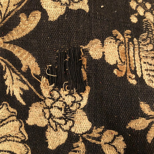 Antique tapestry or table cloth on a black background with rich decorations of Medici vases and flowers