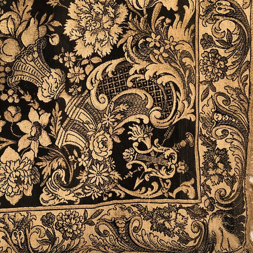 Antique tapestry or table cloth on a black background with rich decorations of Medici vases and flowers