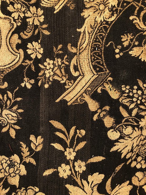 Antique tapestry or table cloth on a black background with rich decorations of Medici vases and flowers