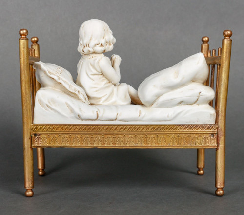 Miniatura a biscotto su letto in bronzo dorato. Fine XIX secolo