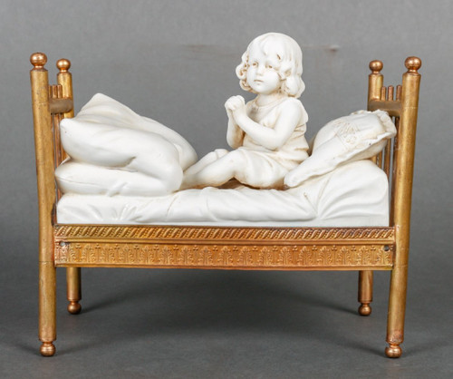 Miniatura a biscotto su letto in bronzo dorato. Fine XIX secolo