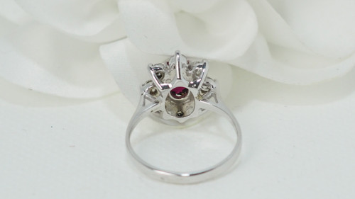 Surrounding ring in white gold, oval ruby and diamonds