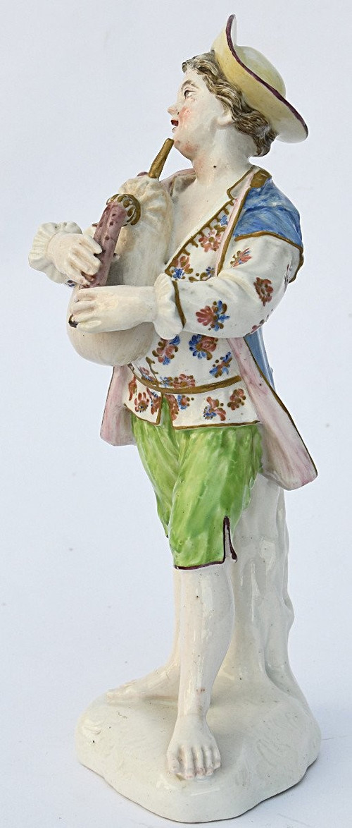 Statuette en porcelaine figurant un jeune garçon jouant de la cornemuse