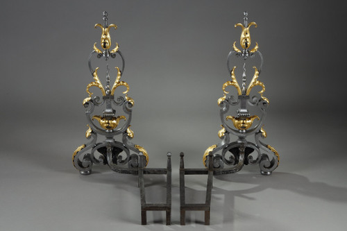 Paire de landiers en fer forgé à décor feuillagé, masque et volutes