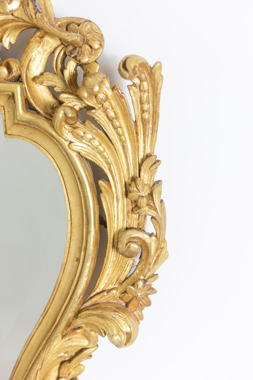 Miroir de style Régence en bois sculpté et doré. Années 1950.