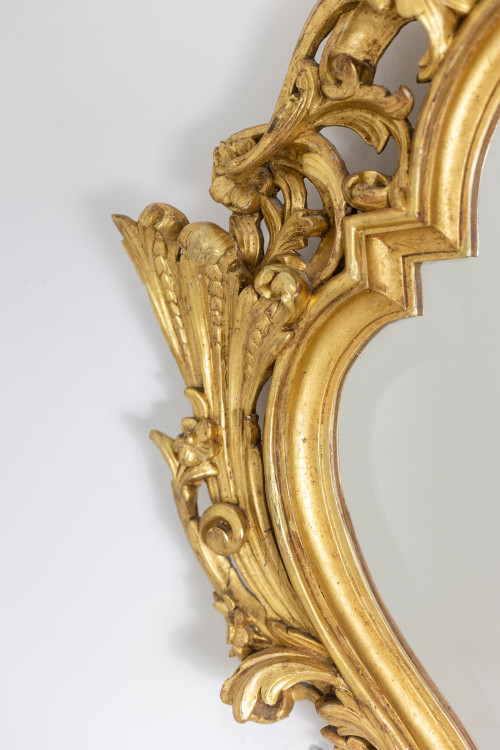 Miroir de style Régence en bois sculpté et doré. Années 1950.