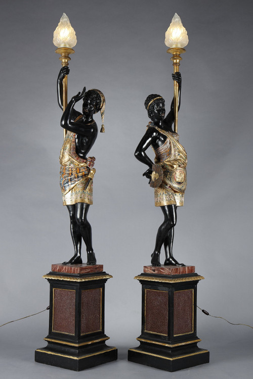 PAIR OF BLACK AND POLYCHROME LACQUERED WOOD TORCHHOLDERS DEPICTING NUBIANS
