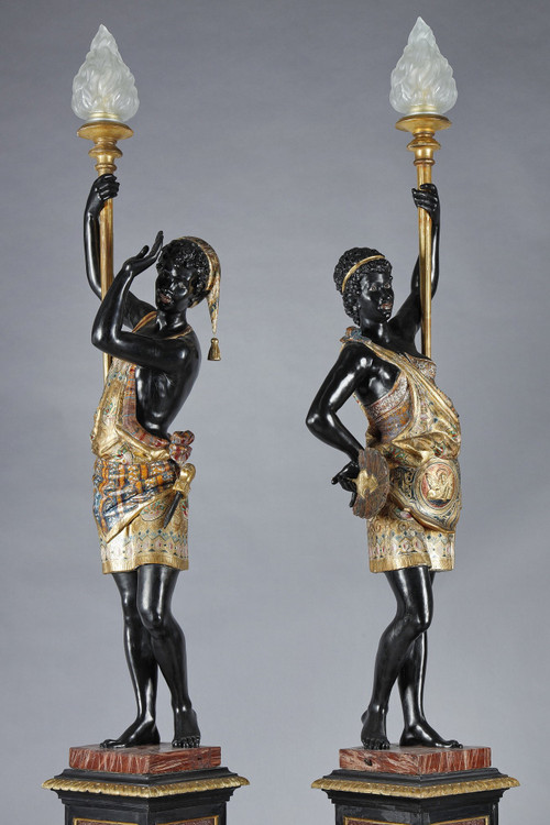 PAIR OF BLACK AND POLYCHROME LACQUERED WOOD TORCHHOLDERS DEPICTING NUBIANS