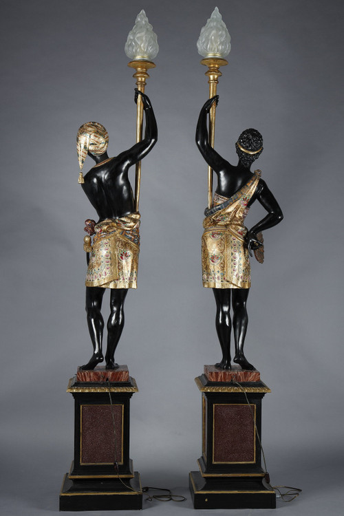 PAIR OF BLACK AND POLYCHROME LACQUERED WOOD TORCHHOLDERS DEPICTING NUBIANS