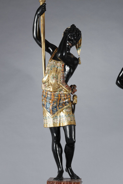 PAIR OF BLACK AND POLYCHROME LACQUERED WOOD TORCHHOLDERS DEPICTING NUBIANS