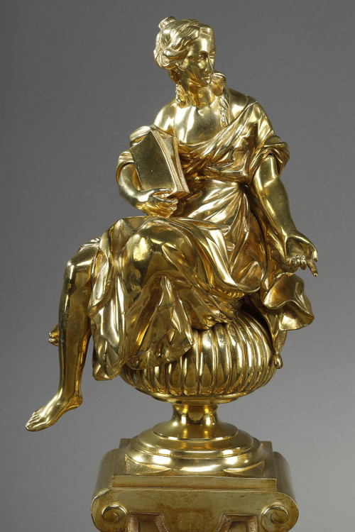 PAIR OF ORMOLU AND CHASED ANDIRONS DECORATED WITH SEATED MUSES