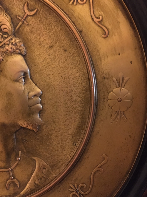Pair of chased and gilded copper medallions, signed P. Faraoni (1869)