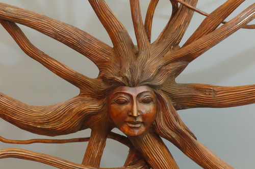 Scultura di un volto femminile con capelli luminosi
