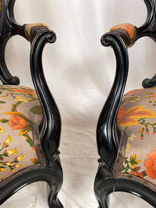 Pair of Napoleon III armchairs, in blackened wood, upholstered in floral fabric.