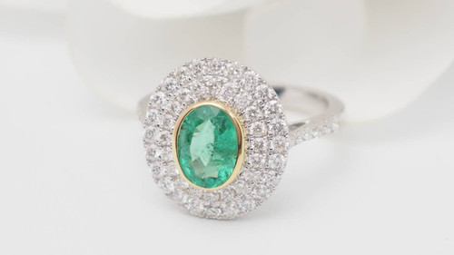 Bague entourage en or bicolore, émeraude ovale et diamants