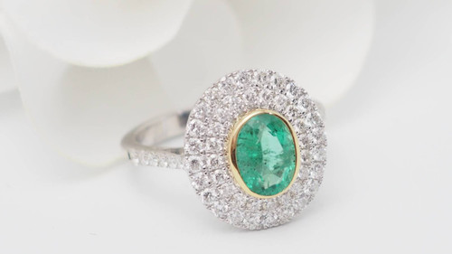 Bague entourage en or bicolore, émeraude ovale et diamants