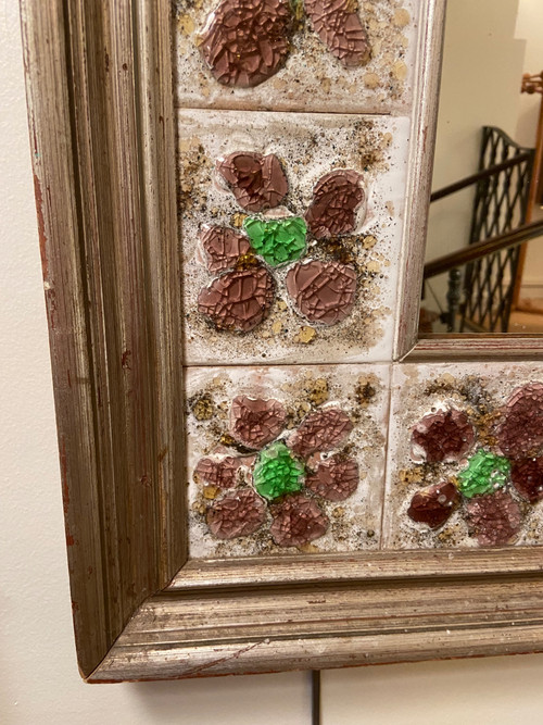 Large square ceramic mirror with floral decoration.